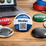 Badges ronds personnalisés pour événements professionnels et festivals, avec QR code et épingle au dos sur table en bois.